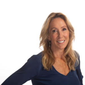 Professional headshot of a smiling woman with shoulder-length blonde hair, wearing a navy blue blouse against a clean white background.